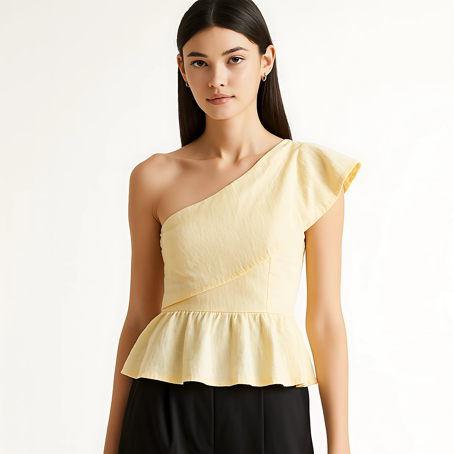 Woman wearing an asymmetric ruffle top with a tailored fit and peplum hem, ideal for eventwear and bridal collections.