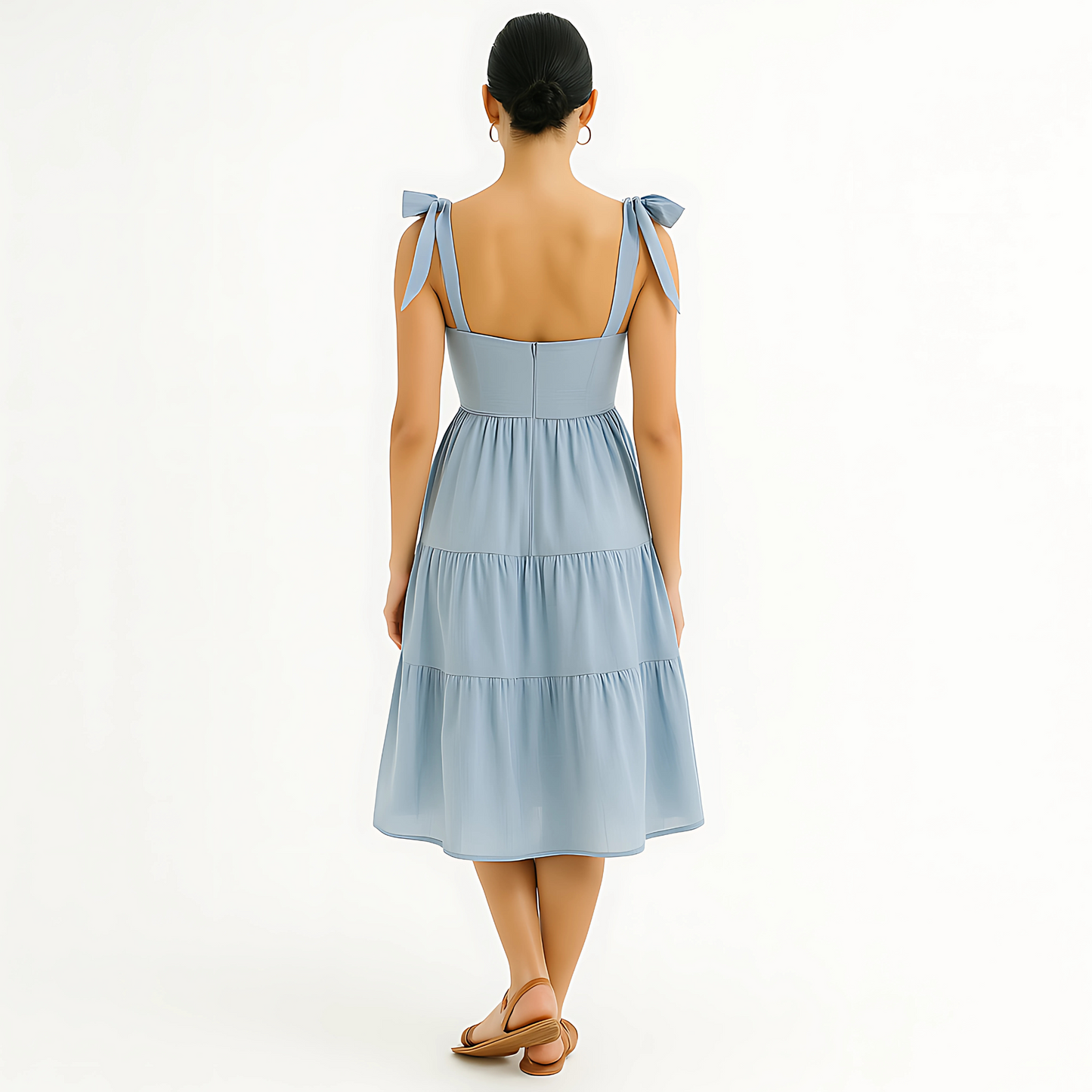 Back view of Clio Tiered Midi Dress in soft powder blue with bow-tied shoulder straps and tiered skirt, ideal for bridal or resortwear.