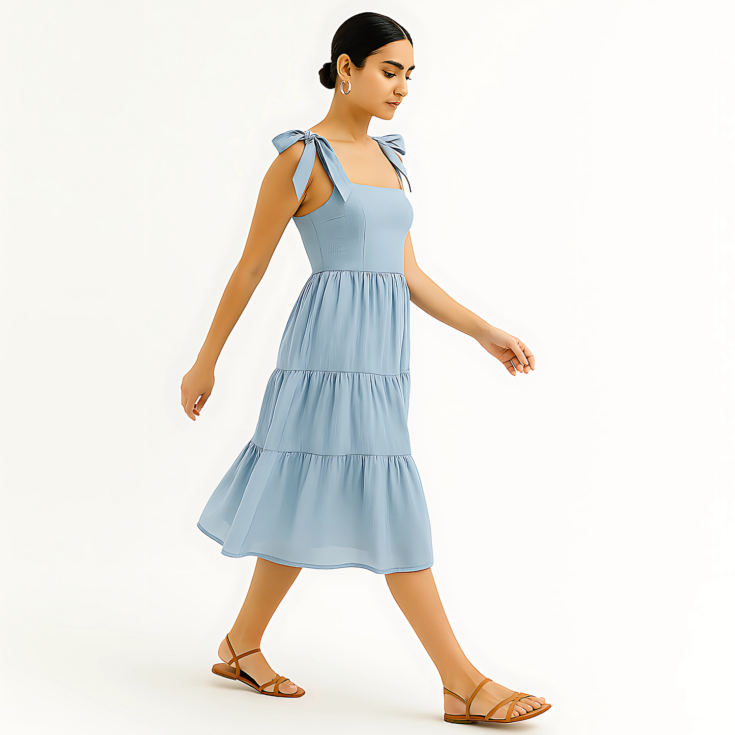 Woman wearing Clio Tiered Midi Dress in powder blue with bow-tied straps, perfect for resortwear and bridal occasions.