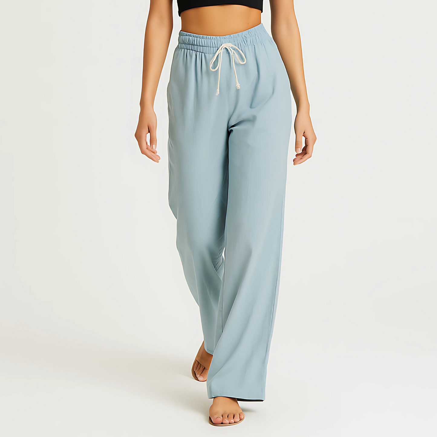Woman wearing Coastal Drape Pant in Powder Blue, featuring a wide-leg cut, elastic waistband, and drawstring, ideal for resortwear.