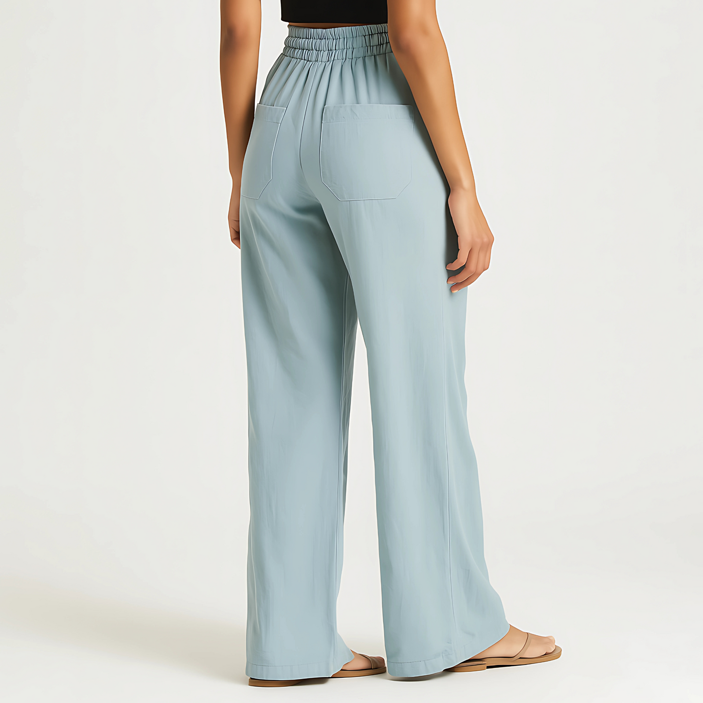 Woman wearing powder blue Coastal Drape Pant with elastic waistband, relaxed wide-leg style, ideal for resortwear and warm weather.
