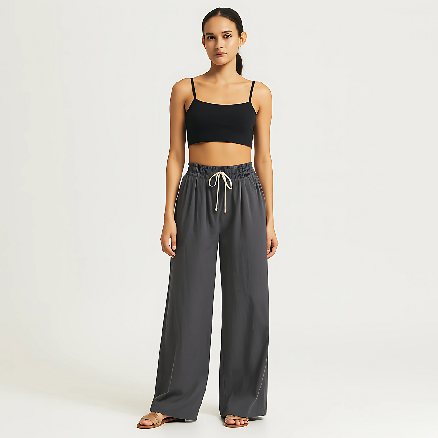 Model wearing charcoal Coastal Drape Pant with wide-leg design, drawstring waist, and functional pockets, ideal for resort and spa wear.
