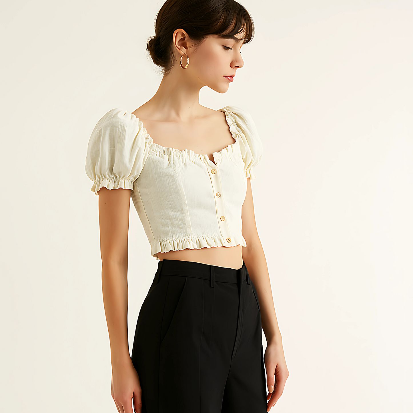 Woman wearing a natural linen button crop top with puff sleeves and ruffle trim, styled for resortwear or feminine collections.