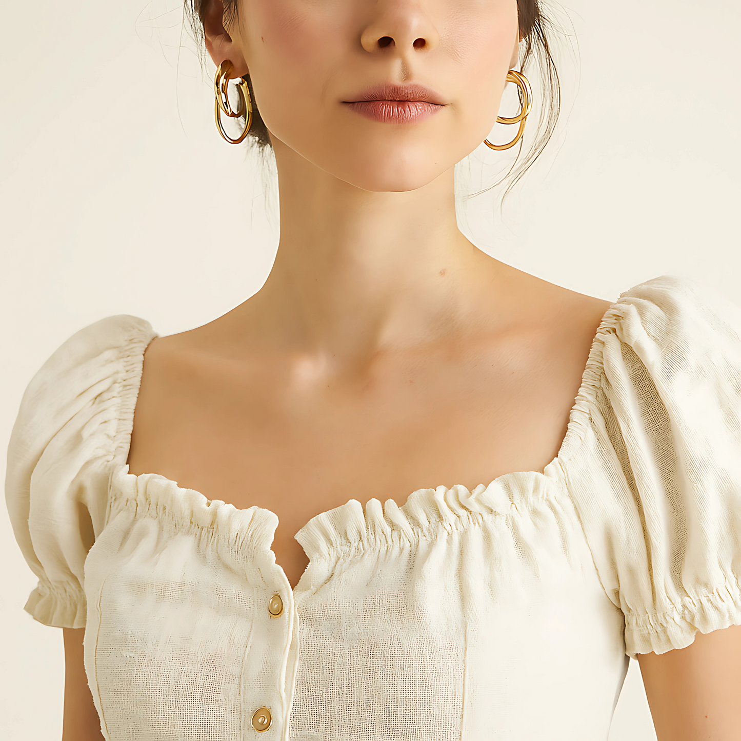 Woman wearing a linen button crop top with a square neck, short puff sleeves, and ruffle trim, shown in natural color.
