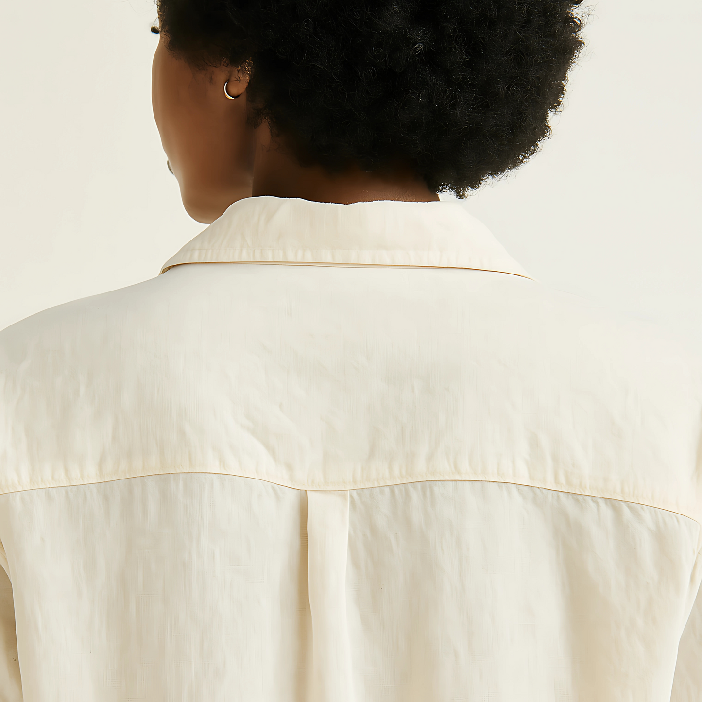 Back view of a natural-colored oversized camp shirt with a relaxed fit and lightweight cotton-linen fabric.