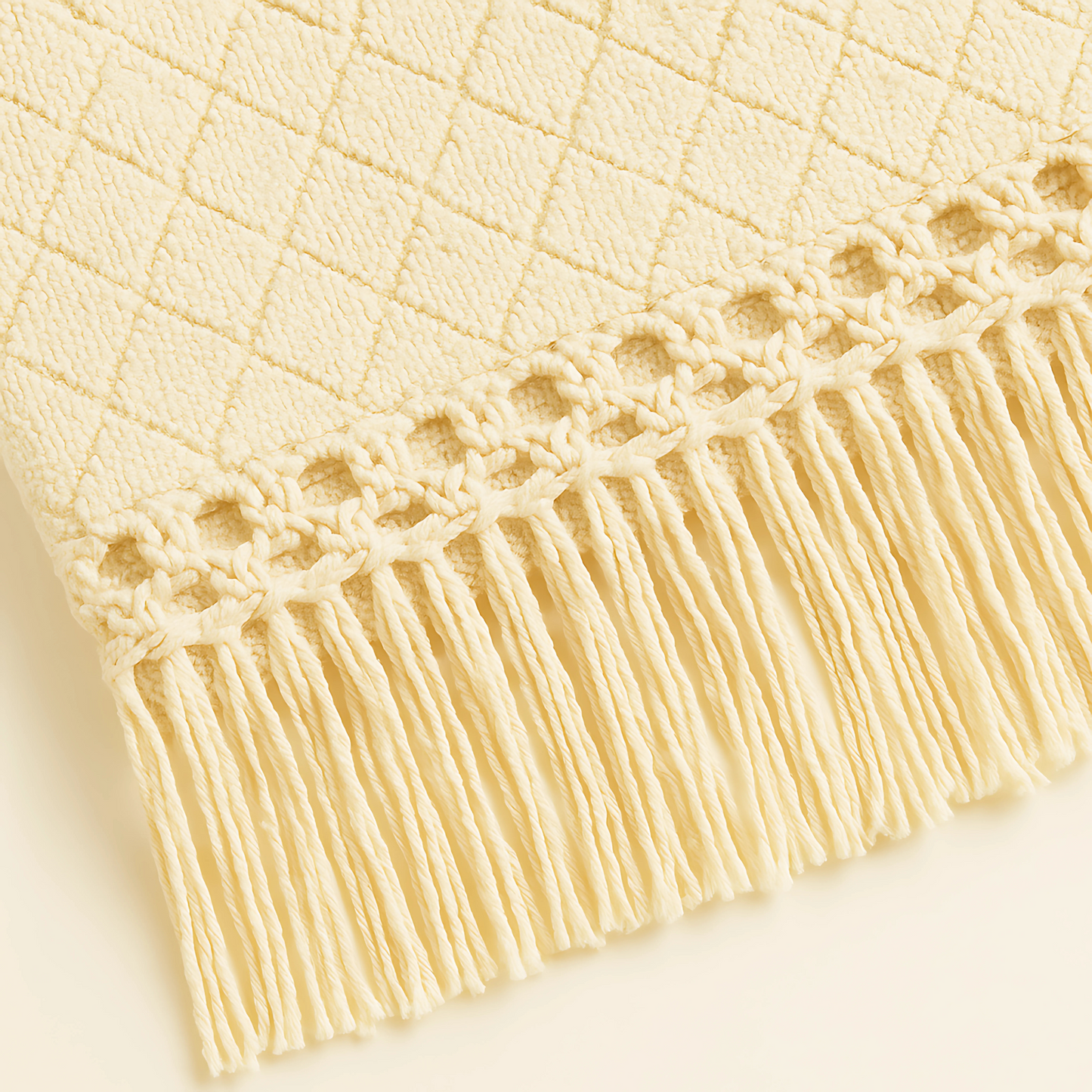 Neutral cream resort blanket with fringe detail, ideal for spa relaxation and luxury gifting, perfect for upscale leisure brands.