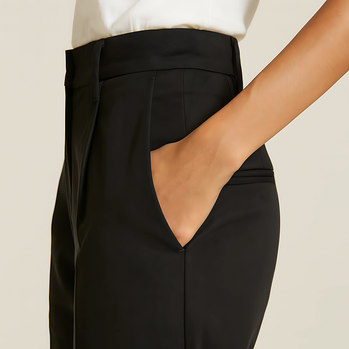 Close-up of a person wearing The Amalfi Tailored Trouser in Jet Black with a sleek design and subtle pleats, ideal for uniforms and style.