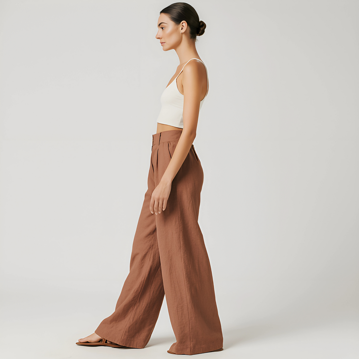 Alt Tag: Woman wearing Solana Linen Trouser in terracotta, featuring wide-leg, high-waist design; perfect for beach or travel wear.