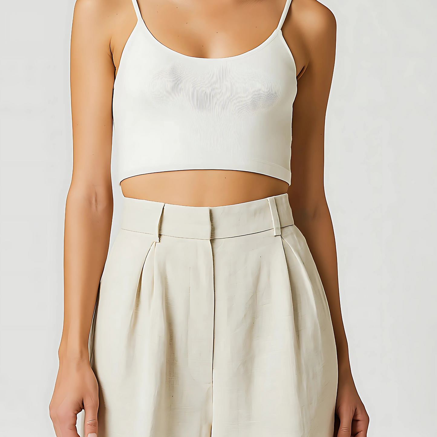 Woman wearing high-waisted ivory Solana linen trousers with wide-leg fit and front pleats, styled for resort or travel wear.