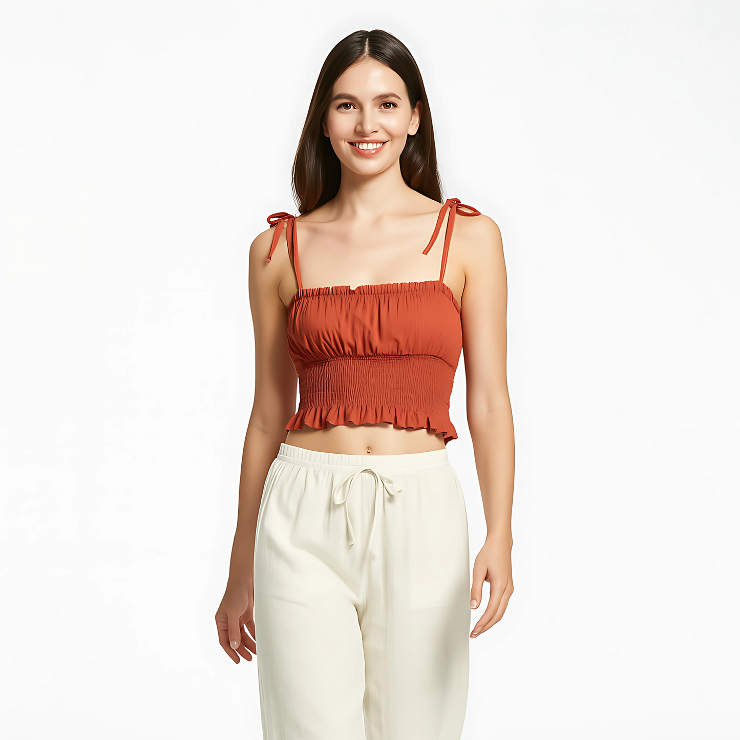 Woman wearing Tie Strap Ruched Cami in terracotta, featuring bow-tied straps, ruched bust, smocked waist, and ruffle hem.