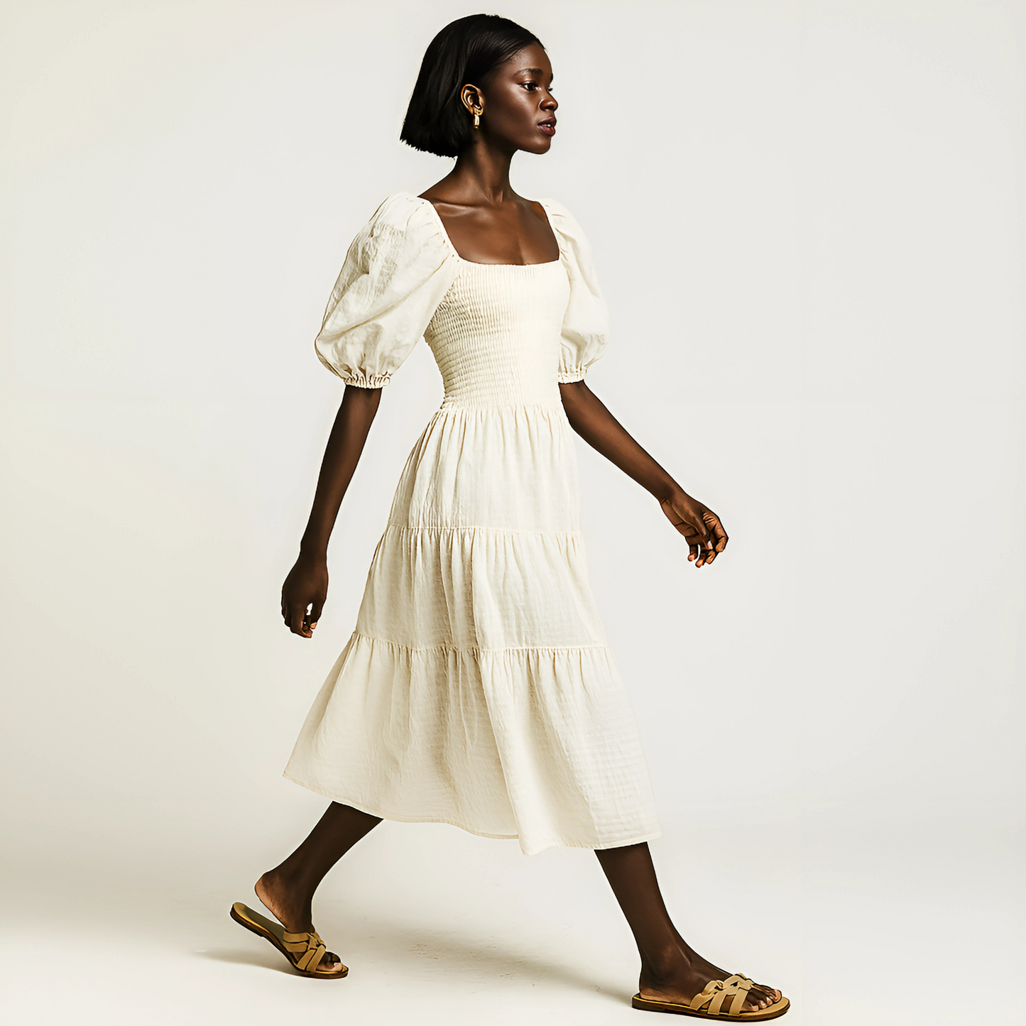 Woman wearing Zadie Puff-Sleeve Midi Dress in soft buttercream, featuring puff sleeves, shirred bodice, and tiered skirt.