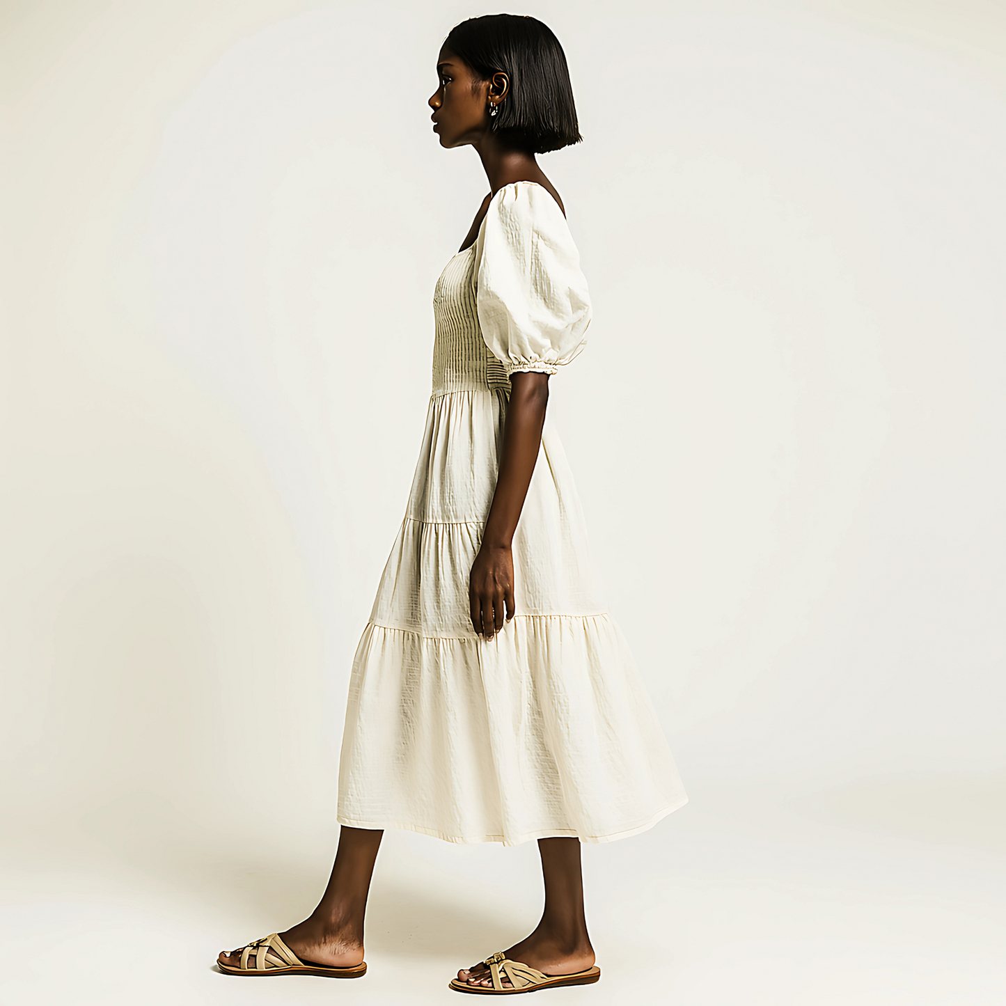 Woman wearing Zadie Puff-Sleeve Midi Dress in Soft Buttercream with a tiered skirt and puff sleeves.