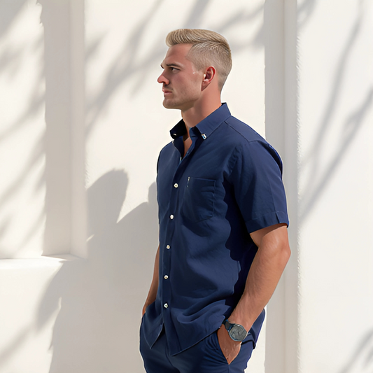 Man wearing Aegean Set in deep marine, featuring a short-sleeve button-down and matching shorts; ideal for resort and travelwear.