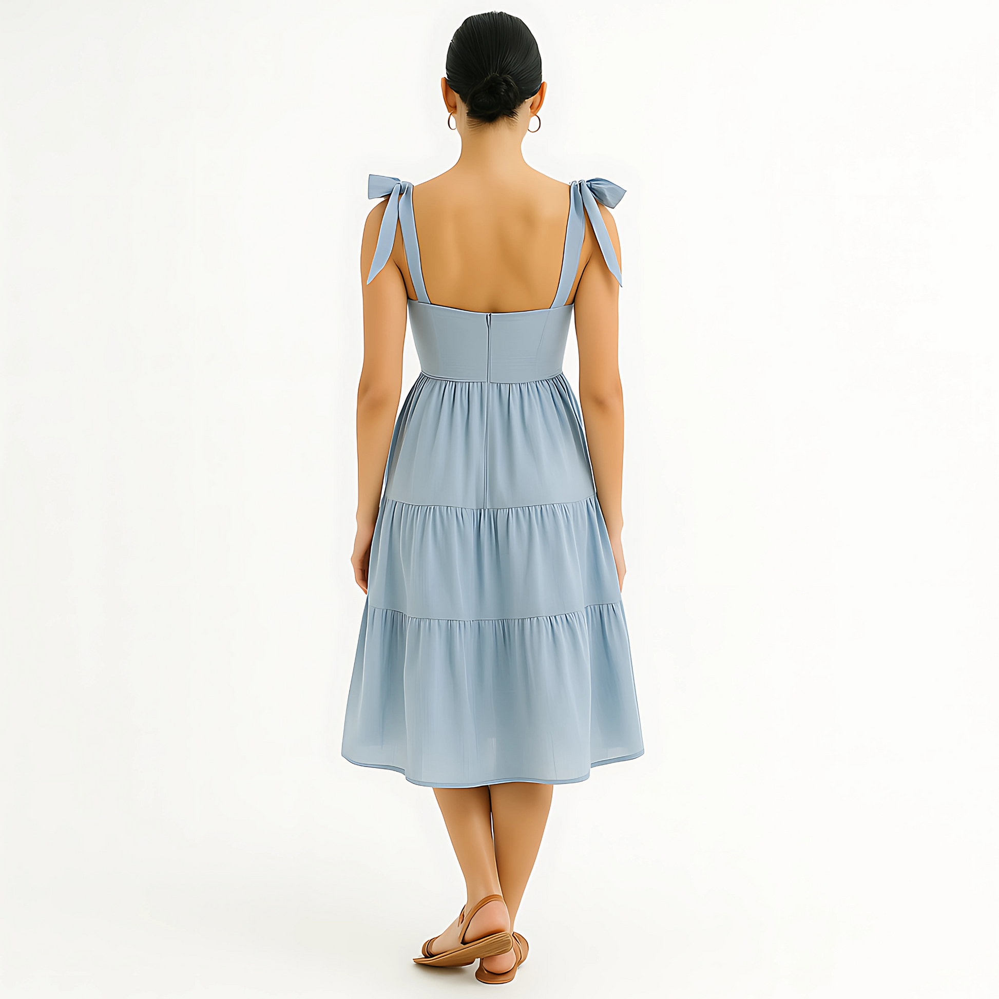 Back view of Clio Tiered Midi Dress in soft powder blue with bow-tied shoulder straps and tiered skirt, ideal for bridal or resortwear.