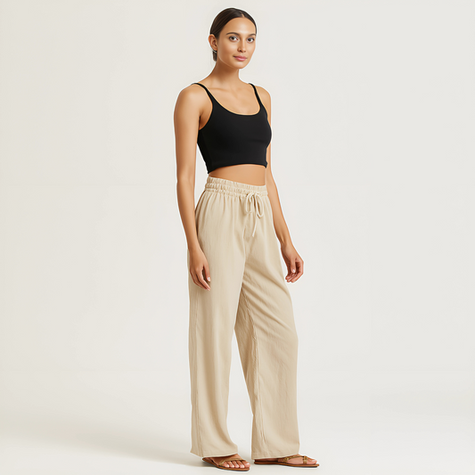 Model wearing Coastal Drape Pant in Natural, featuring a relaxed wide-leg design with elastic waistband, ideal for resortwear.