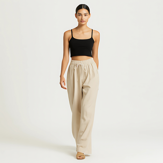 Woman wearing Coastal Drape Pant in Natural color, featuring elastic waistband and wide-leg style for resortwear.