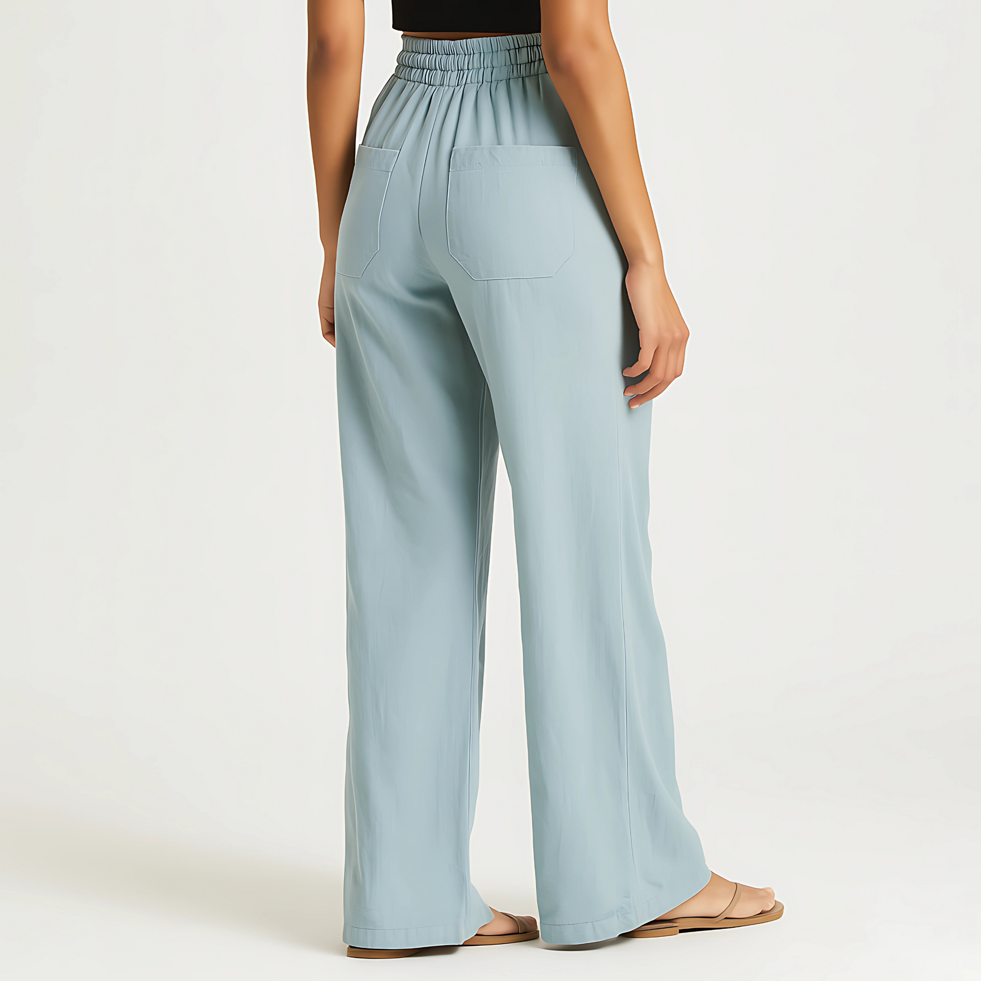 Woman wearing powder blue Coastal Drape Pant with elastic waistband, relaxed wide-leg style, ideal for resortwear and warm weather.