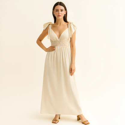 Delphine Ruffle Strap Maxi Dress in ivory with plunging neckline, ruffle tie straps, and open back, ideal for beach events and bridal settings.