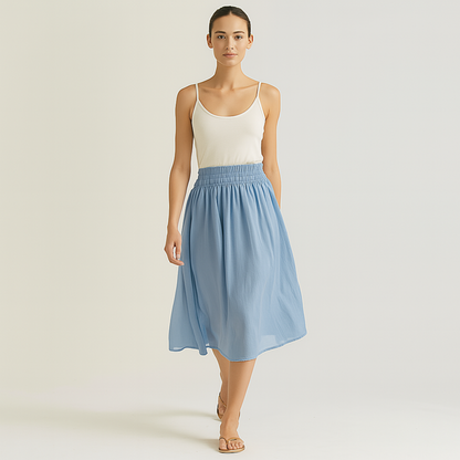 Woman wearing Isla Elastic Midi Skirt in Cloud Blue with elastic waistband, styled for resort, spa, or travelwear.
