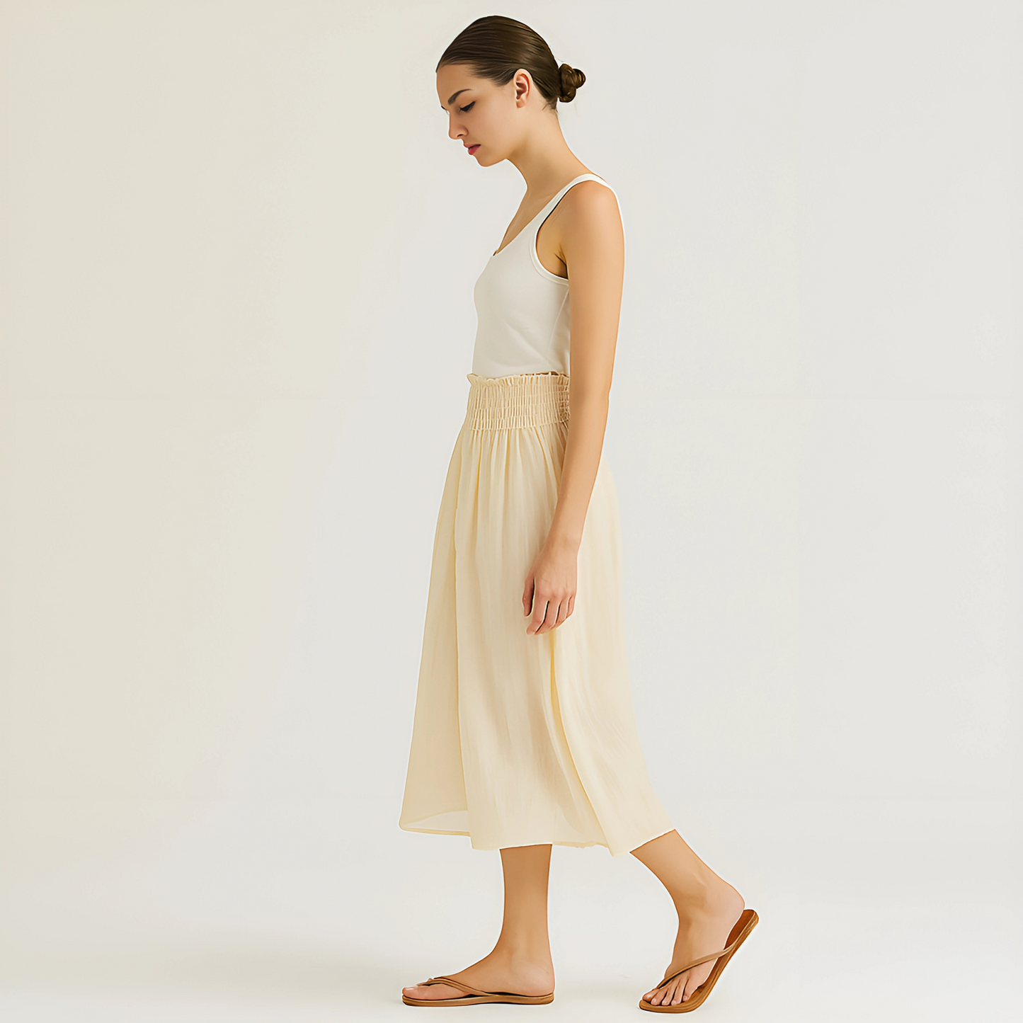 Woman wearing Isla Elastic Midi Skirt in Vanilla, showing off the elastic waistband and flowing design, ideal for resort or travel.