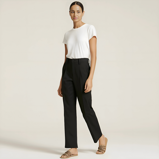 Model wearing The Amalfi Tailored Trouser in Jet Black, showcasing pleated, tapered fit with a minimal waistband, perfect for versatile styling.