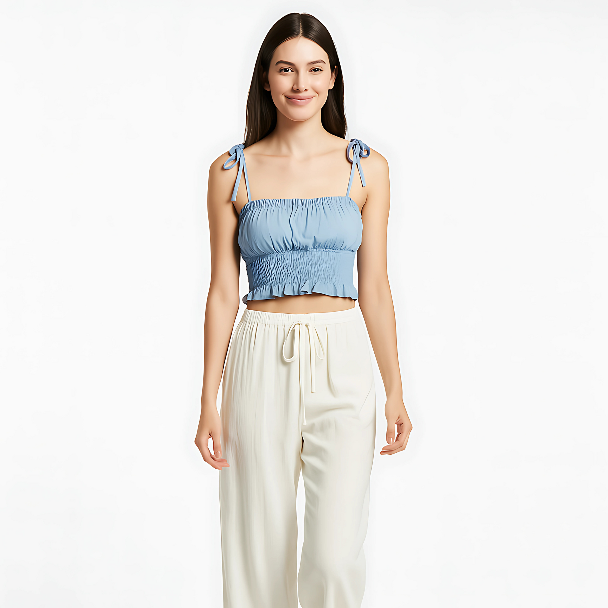 Sky blue ruched cami with bow-tied straps and ruffle hem, perfect for summer and resort wear, paired with cream-colored trousers.