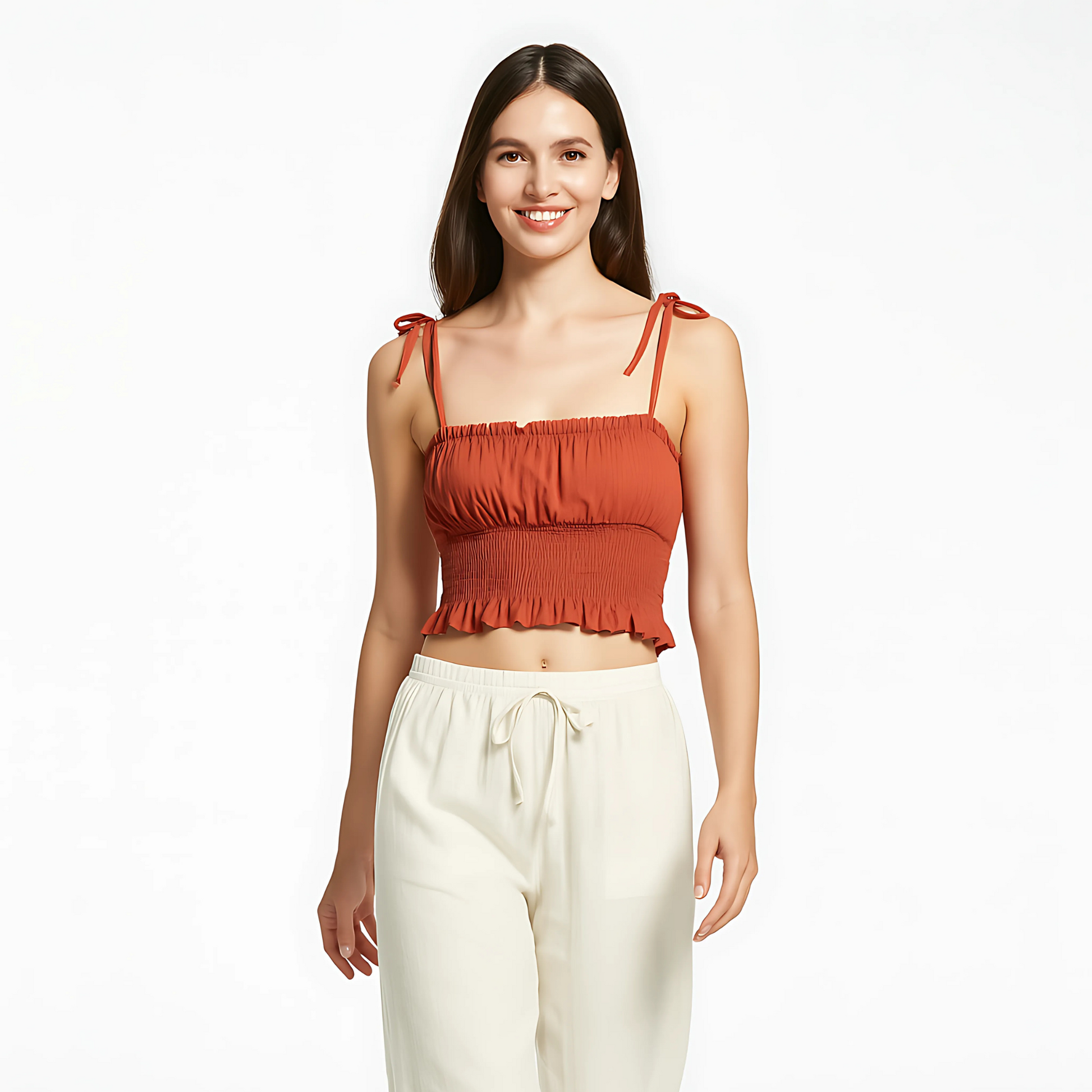 Woman wearing Tie Strap Ruched Cami in terracotta, featuring bow-tied straps, ruched bust, smocked waist, and ruffle hem.