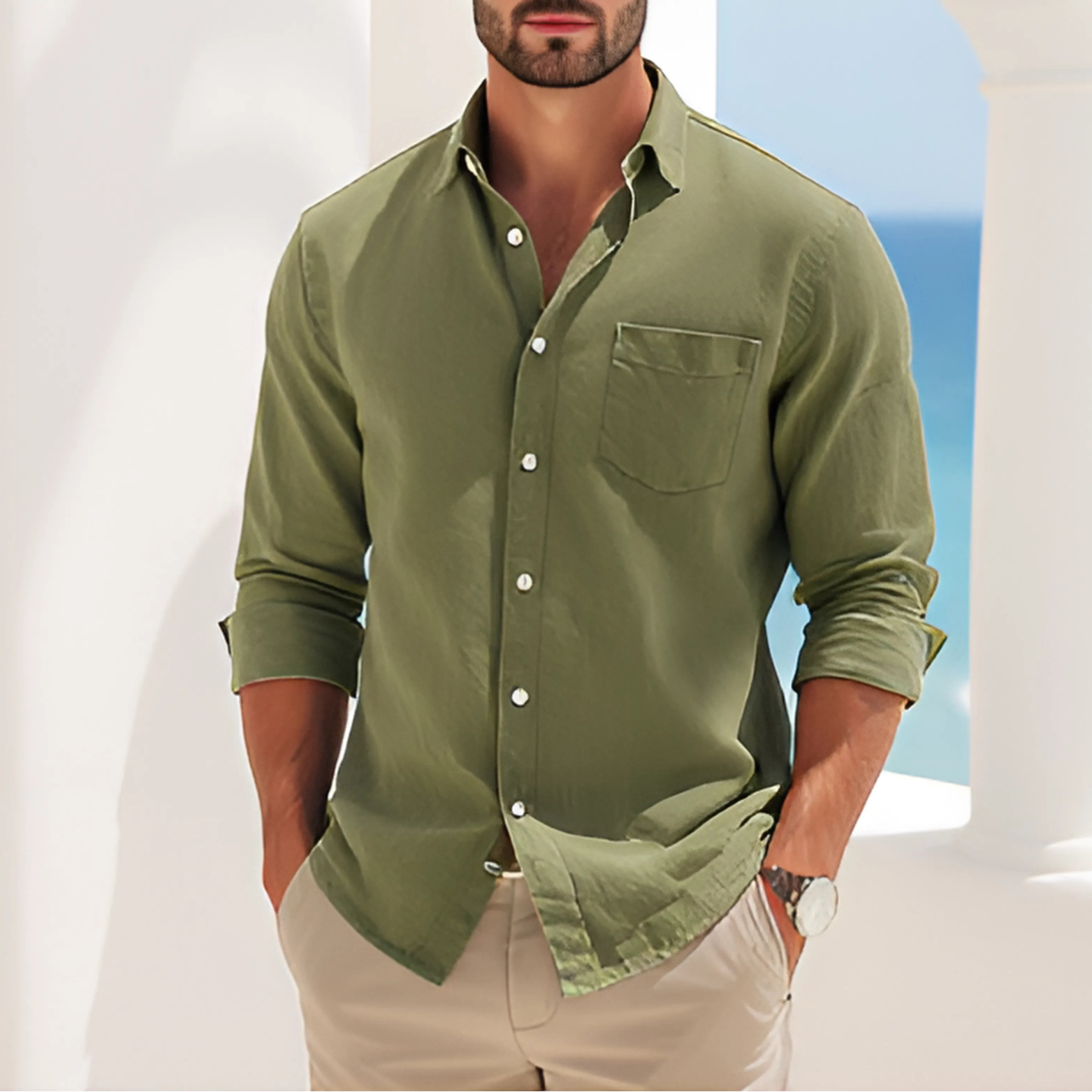 Man wearing a Verde Coastline Shirt, standing against a coastal background with ocean view. Casual and elegant style in green.